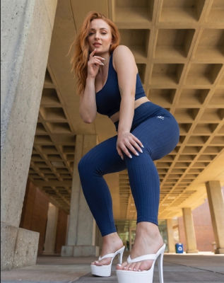 AI-generated image of Sophie Turner posing in athletic wear under a concrete structure