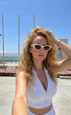 AI-generated image of an unidentified woman in a white zip-front top at a beachfront