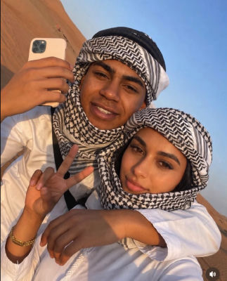 AI-generated selfie of two people in keffiyehs at a desert location