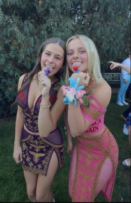 AI-generated image of two young women in patterned formal dresses at an outdoor event