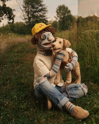 AI-generated image of a cloth doll hugging a stuffed dog in a grassy field