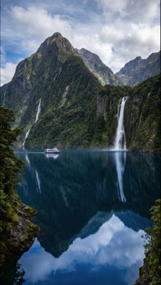 AI-generated image of a fjord with waterfalls and a tour boat