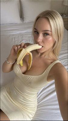 AI-generated image of a blonde woman eating a banana on a bed