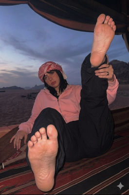 Deepfake image of Kali Uchis reclining in a desert at dusk