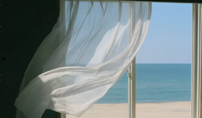 AI-generated image of a curtain billowing at a beachfront window