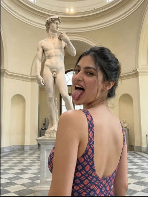 AI generated of image of a woman Posing Playfully in Front of Michelangelo's David Statue