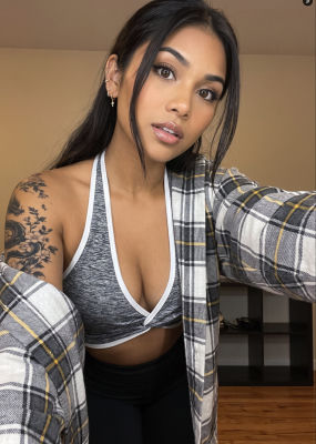 AI-generated selfie of a woman with shoulder tattoos in a plaid shirt