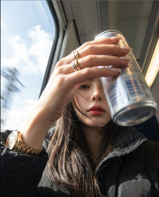 AI-generated selfie of a woman holding a Red Bull can on public transit