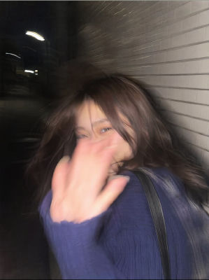 AI-generated blurry selfie of a woman with hand over face