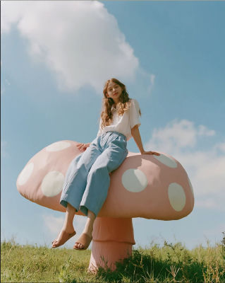 AI-generated image of a woman seated on a giant pink mushroom