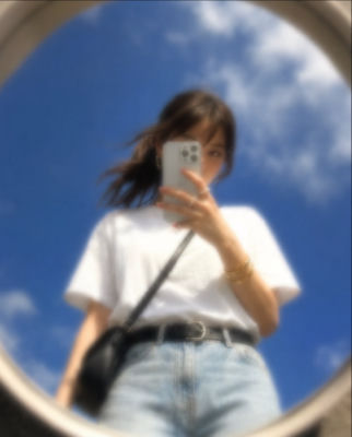 AI-generated selfie of a woman reflected in a round mirror