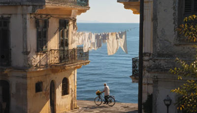 AI-generated coastal street scene with elderly man and bicycle