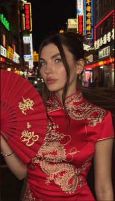 AI-generated image of a woman in a red qipao with a folding fan in Chinatown