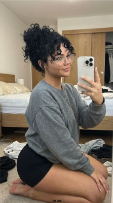 AI-generated mirror selfie of an unidentified woman in a bedroom
