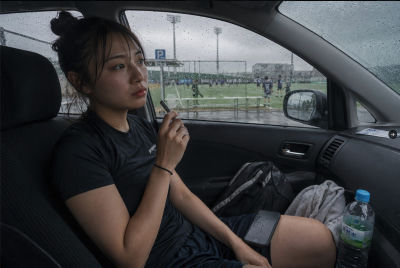 AI-generated image of a woman in a car at a rainy soccer field