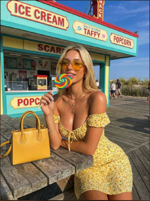 AI-generated image of a woman with a rainbow lollipop at a boardwalk candy stand