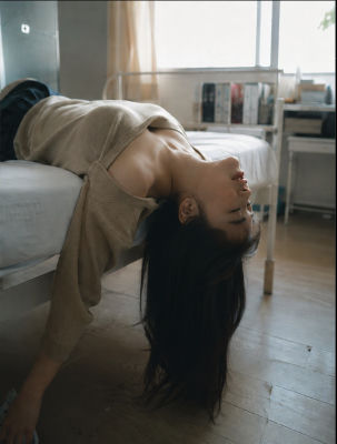AI-generated portrait of an unidentified woman draped backwards over a bed