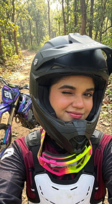 AI-generated selfie of a woman in motocross gear on a forest trail