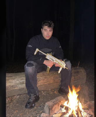 AI-generated image of a man with a jeweled prop rifle by a campfire