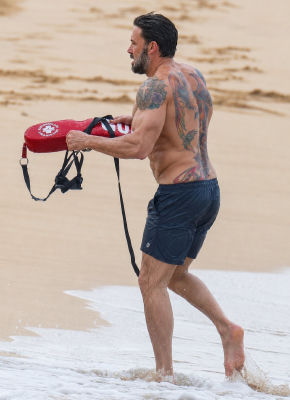 AI-generated image of Ben Affleck carrying a lifeguard buoy on a beach