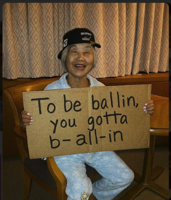 AI-generated image of an elderly woman holding a 'To be ballin, you gotta b- all-in' sign