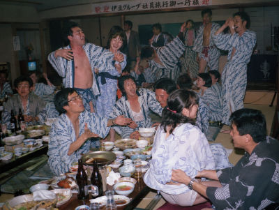 Deepfake image resembling Hiroshi Itsuki, Jun Kunimura, and Claude Maki at a Japanese company banquet