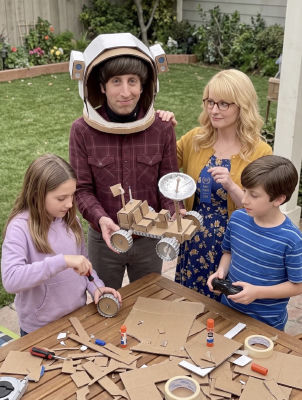Deepfake image detected of two adults and two children displaying a cardboard space rover