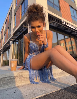 Deepfake of Zendaya sitting outside a Starbucks in a blue fringe dress