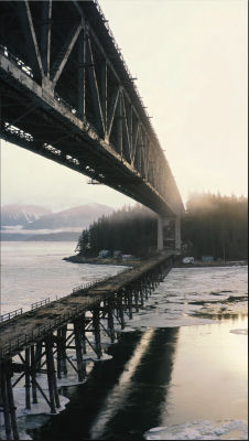 AI-generated image of a large steel truss bridge over icy coastal waters