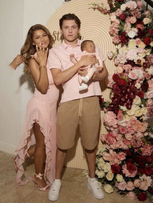 AI-generated family portrait featuring an infant with Zendaya and Tom Holland at a floral backdrop