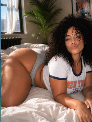 AI-generated image of a woman in a New York Bronx t-shirt on a bed