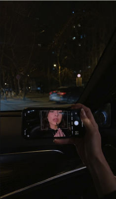 AI-generated image of a smartphone displaying a woman's portrait inside a car at night