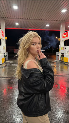 AI-generated image of a woman smoking at a gas station at night