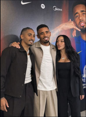 AI-generated image of Gabriel Jesus at a promotional event with a woman wearing a '1Win' necklaces