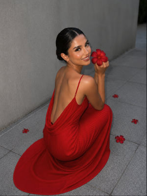 AI-generated portrait of a woman in a red backless dress with a red flower