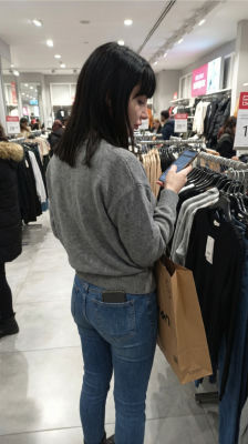 AI-generated image of a woman browsing clothing in a retail store