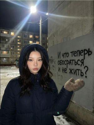 AI-generated image of a woman beside Russian-language graffiti on a wall