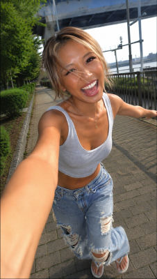 AI-generated selfie of an unidentified woman in a cropped tank top