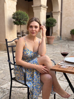 Deepfake of Elizabeth Olsen seated at an outdoor café