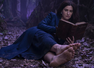 Deepfake of Kathryn Hahn reading a leather-bound book in a forest