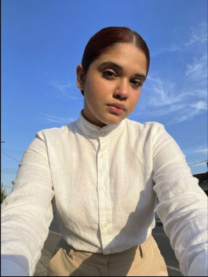 AI-generated selfie of a young woman in a white shirt