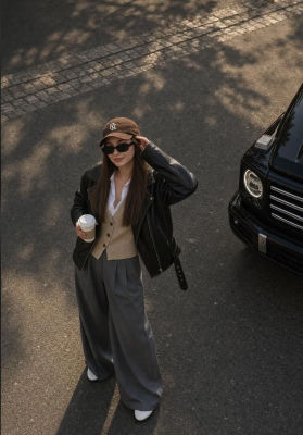 AI-generated image of a woman in streetwear holding a coffee cup beside a black SUV