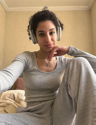 AI-generated selfie of an unidentified woman wearing headphones in a bedroom