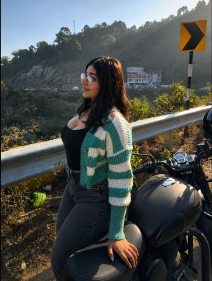 Deepfake of an unidentified woman seated on a motorcycle on a hillside road