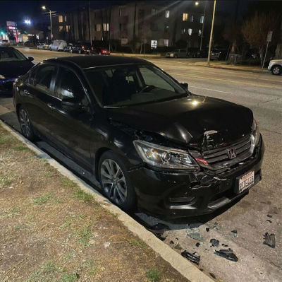 AI-generated image of a damaged black Honda sedan on a street
