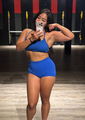 AI-generated mirror selfie of a woman in athletic wear at a gym
