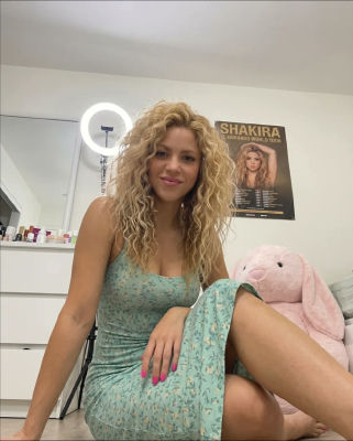Deepfake of Shakira posing in a floral dress with El Dorado World Tour poster
