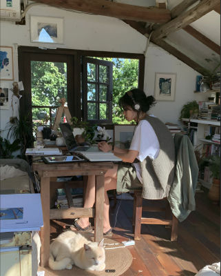 AI-generated image of an unidentified woman working at a desk with a cat