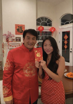 AI-generated image of Jackie Chan and a woman holding a Chinese New Year hongbao