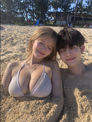 AI-generated beach selfie of a young couple in the sand